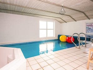 An indoor swimming pool with a tiled floor, a window, and exercise balls. - 4 Star Holiday Home in Nordborg (Nordborg)