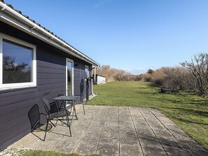 A house with a patio, a table, and chairs.