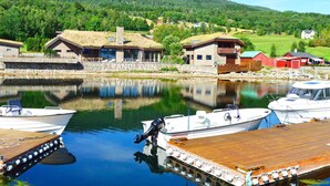 A lakeside property with a dock, boats, and buildings with thatched roofs. - Holiday Home in EidsvÃ¥g (Molde)