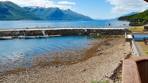 A lakeside view with a stone pier, boats, and a wooden building. - Holiday Home in EidsvÃ¥g (Molde)