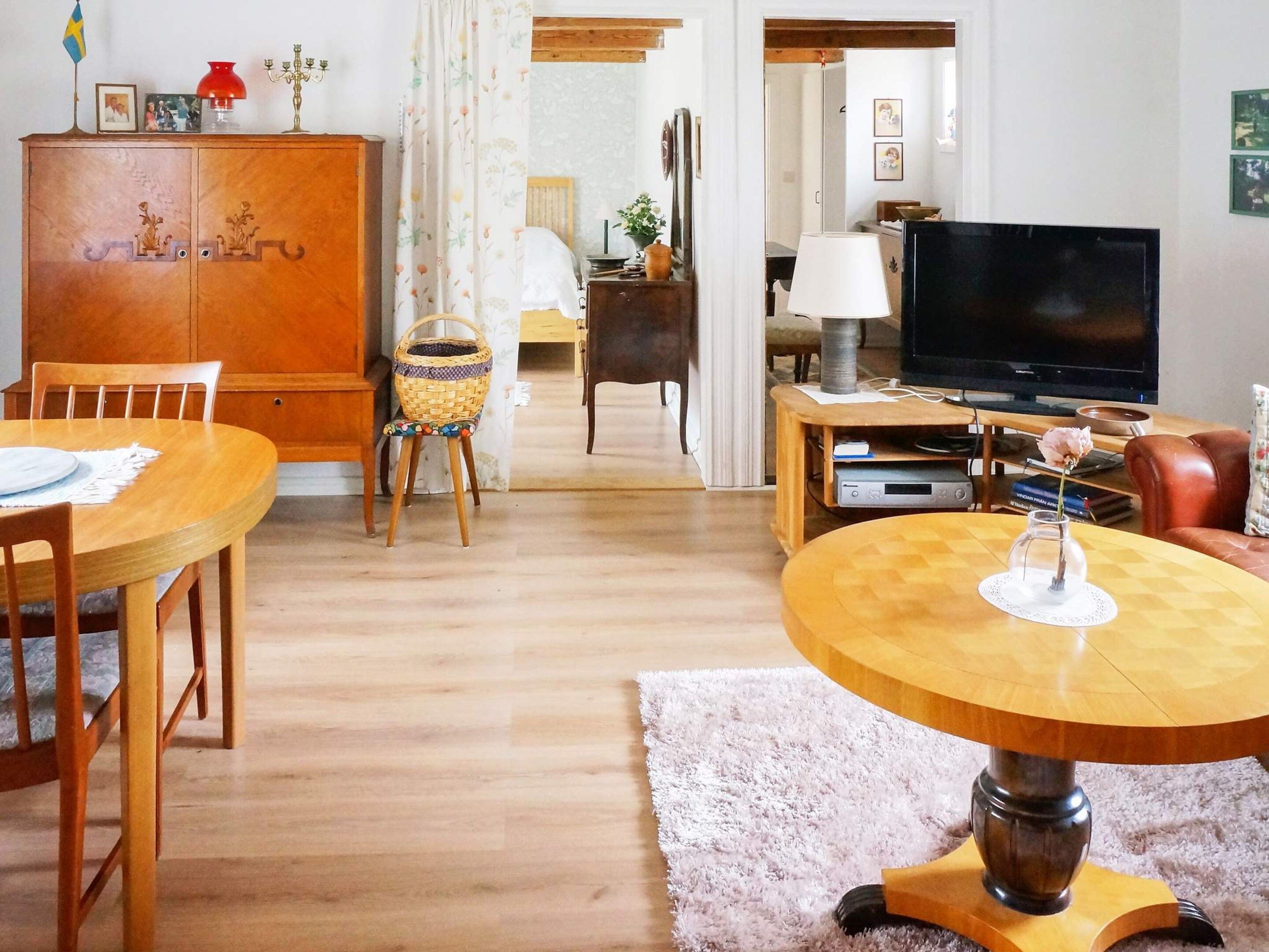 A living room with a wooden dining table, a television, and a sofa.