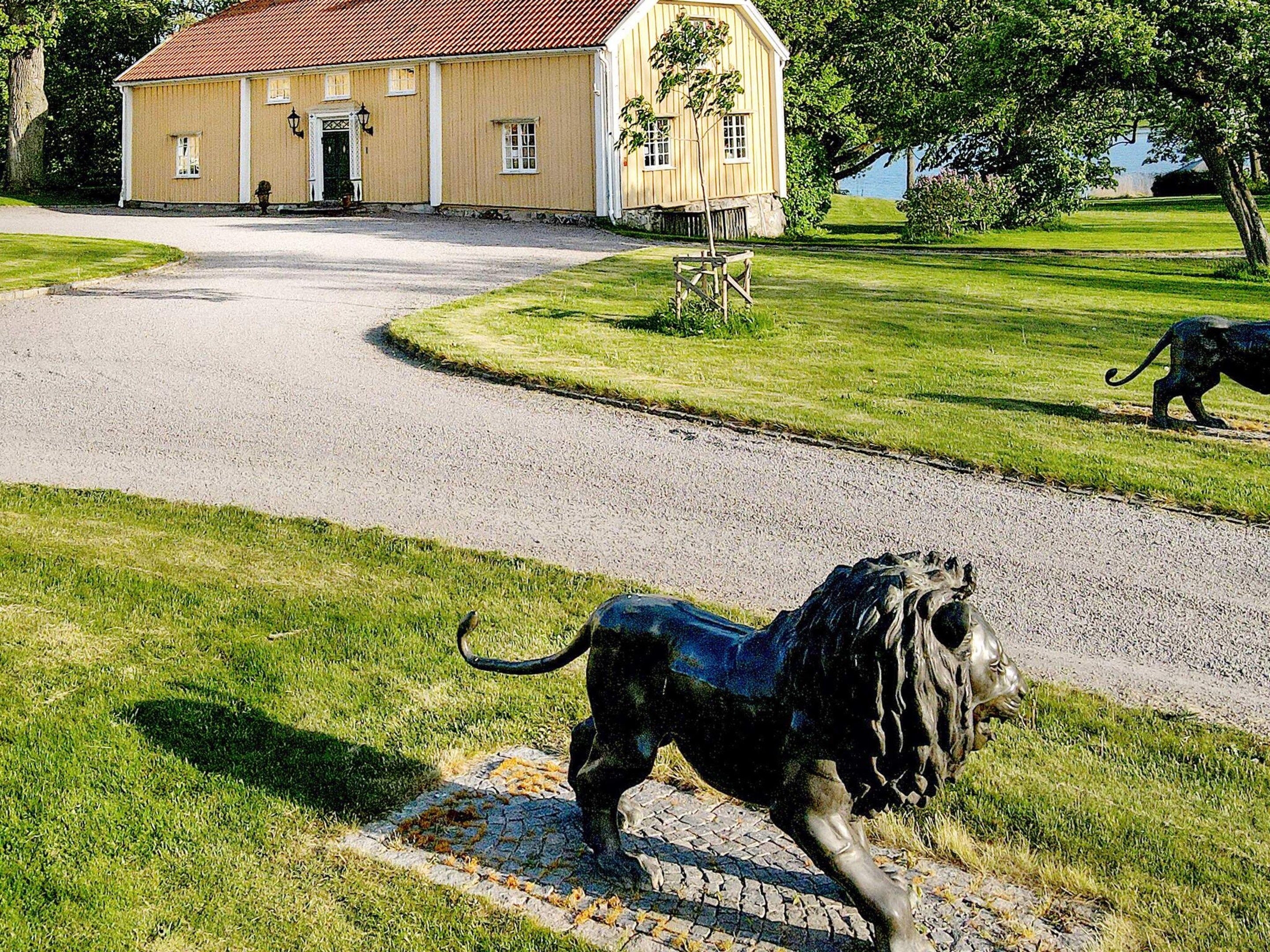 A building with a red roof and a paved driveway leading to it.