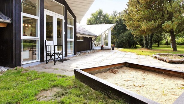 A modern house with large windows, a patio, and a garden area. - 4 Star Holiday Home in Oksbol (Oksbol)