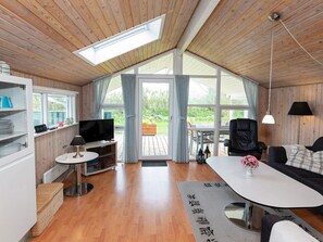 A modern living room with a TV, seating area, and a view of the outdoors. - 6 Person Holiday Home in Hjorring (Hjørring)