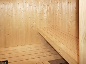 A wooden sauna room with benches and a sloped floor. - Holiday Home in Wendtorf (Wendtorf)