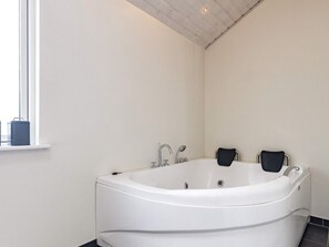 A modern bathroom with a freestanding bathtub, a window, and a tiled floor. - 5 Star Holiday Home in Skals (Skals)