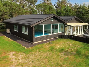 A modern house with a swimming pool, large windows, and a covered patio area. - 4 Star Holiday Home in Vejers Strand (Vejers Strand)