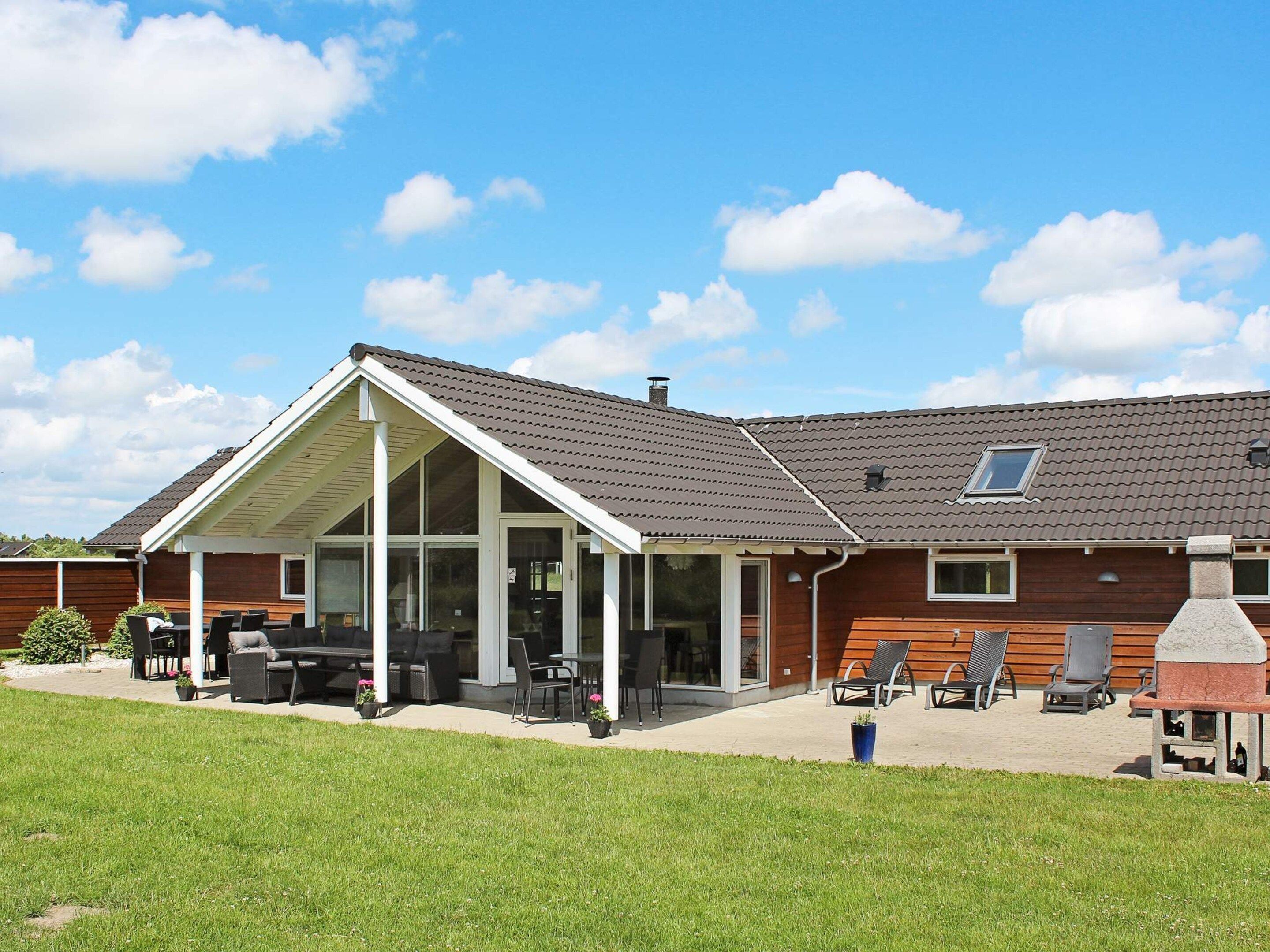 A house with a covered patio, outdoor seating, and a barbecue area.