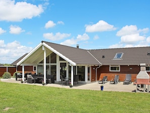 A house with a covered patio, outdoor seating, and a barbecue area. - 5 Star Holiday Home in Idestrup (Idestrup)