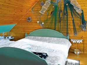 A wooden-paneled room with a bed, a small table, and a wall-mounted lamp. - 6 Person Holiday Home in Askeron (Hjaelteby)