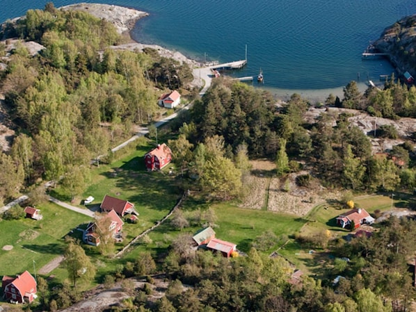 Ilmakuva rannikkokylästä, jossa näkyy taloja, laituri ja pieni satamalaituri.
