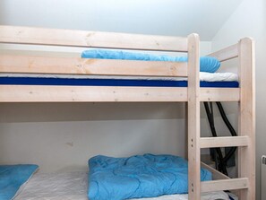 A bunk bed with a ladder, a mattress, and a blue blanket. - 4 Person Holiday Home in Hovborg (Hovborg)