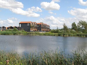 A lakeside hotel with multiple buildings, a dock, and surrounding vegetation.