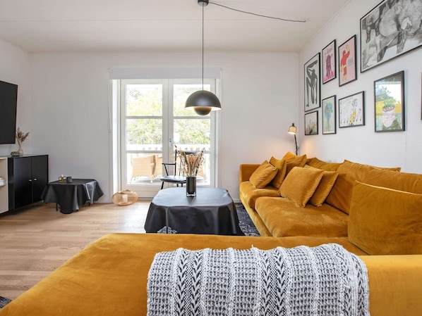 Un salon moderne avec un canapé, une table et une grande fenêtre.