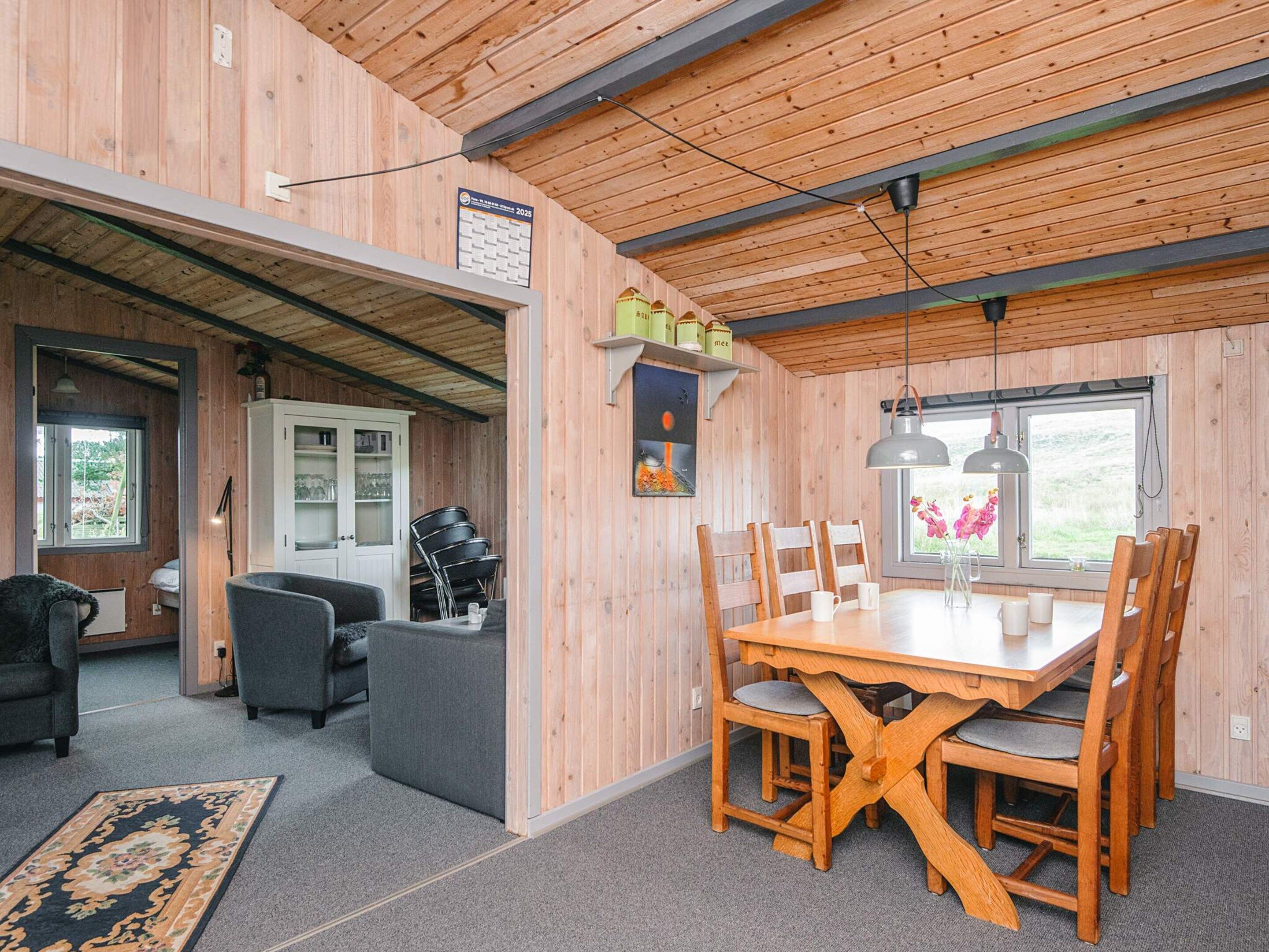 Un intérieur en bois comprenant une table à manger, des chaises, un canapé et un meuble.