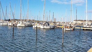 A marina with multiple sailboats docked at wooden piers.