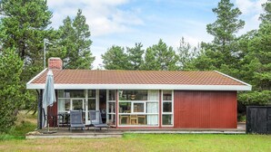 Ett envåningshus med en röd fasad och en täckt uteplats.