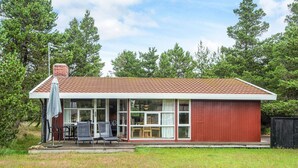 Ett envåningshus med en röd fasad och en täckt uteplats.