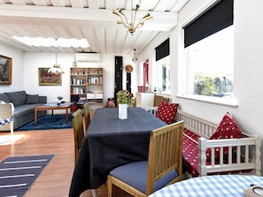Ein gemütliches Wohnzimmer mit einer Couch, einem Esstisch und einem Bücherregal.