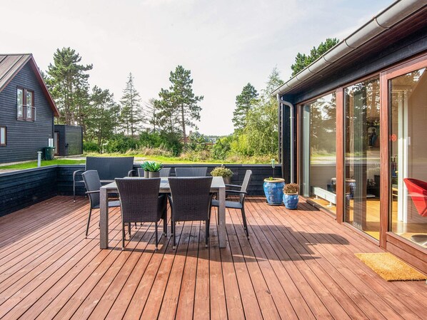 A wooden deck with outdoor furniture and potted plants.