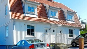 A two-story house with a red-tiled roof, white exterior walls, and a garage. - Holiday Home in Lysekil (Lysekil)