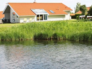A house with a red roof, a large glass window, and a white exterior.