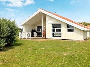 A single-story house with a sloped roof, a covered porch, and a large window. - Holiday Home in Otterndorf (Otterndorf)
