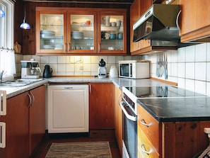 A kitchen with wooden cabinets, a microwave, a coffee maker, and a dishwasher.