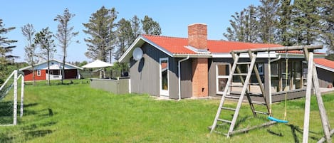 A residential property with a house, a fenced yard, and a swing set.