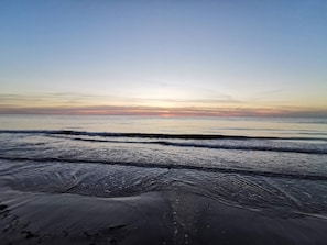 Une plage avec des vagues et un ciel dégagé.