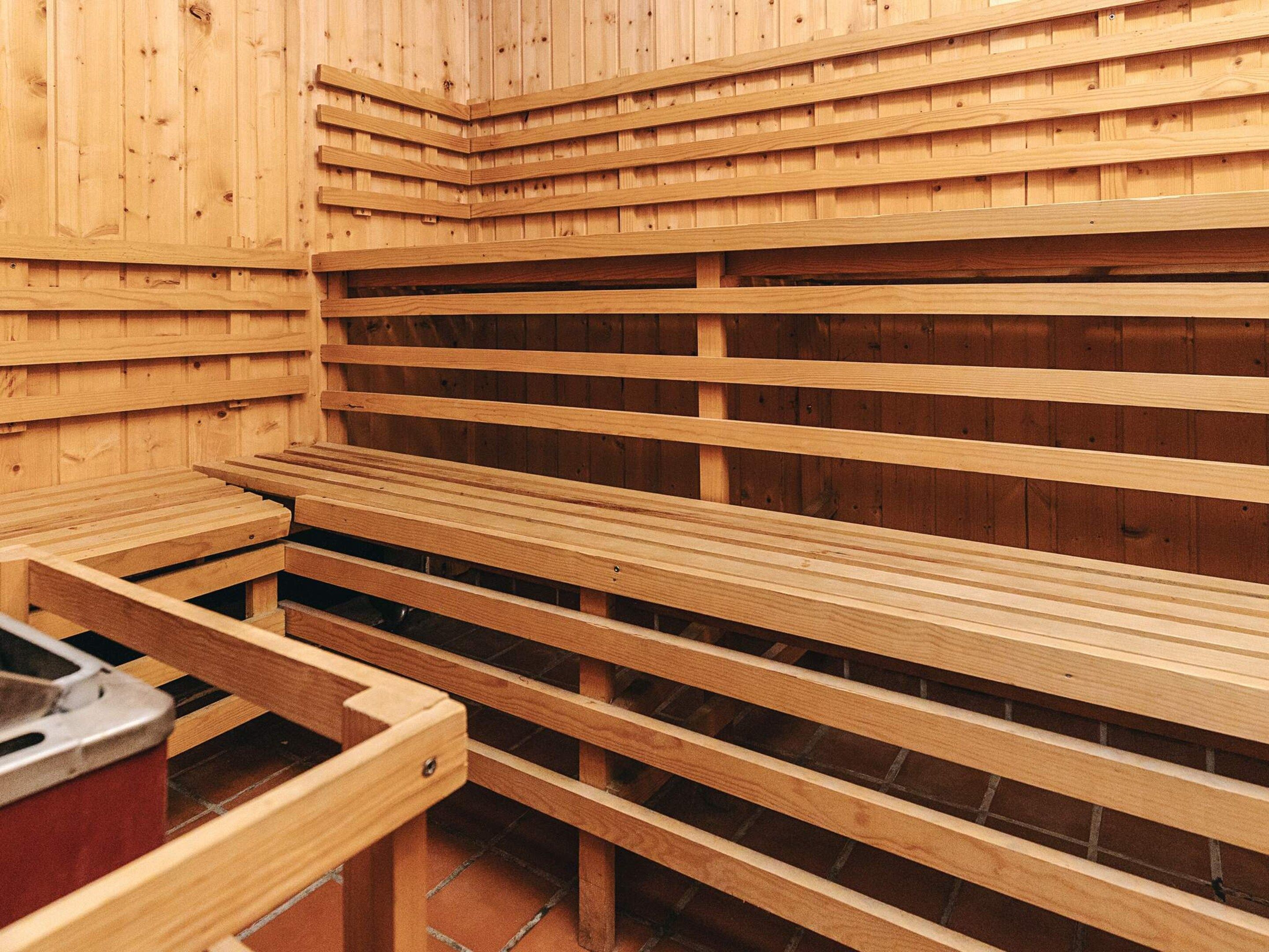 Een sauna met houten banken in rijen opgesteld.
