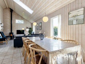 Een moderne keuken met een groot keukenblok, houten stoelen en een ruime raam.