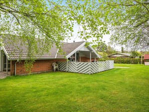 A house with a brick exterior, a covered porch, and a well-maintained lawn. - 4 Star Holiday Home in Juelsminde (Horsens)