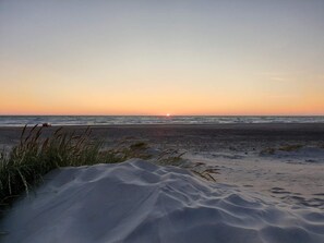A beach with sand dunes and the ocean at sunset. - 6 Person Holiday Home in Hirtshals (Hirtshals)