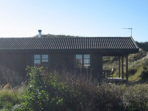 A wooden cabin with a sloped roof, two windows, and a chimney. - 6 Person Holiday Home in Hirtshals (Hirtshals)