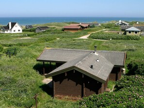 A coastal property with multiple buildings, a grassy landscape, and a view of the sea. - 6 Person Holiday Home in Hirtshals (Hirtshals)