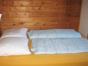 A bed with two pillows and a yellow bedspread. - 6 Person Holiday Home in Hirtshals (Hirtshals)