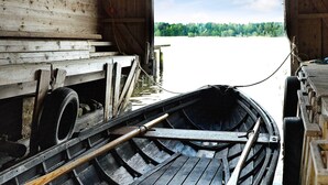 A wooden boat with a bench and a tire on the dock. - Holiday Home in Väddö (Väddö)