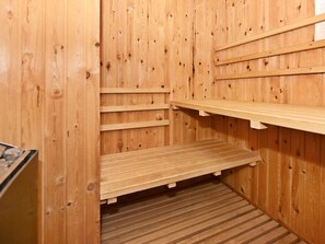 Una sauna de madera con bancos y estantes.