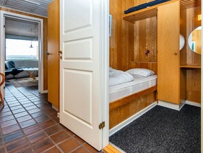 A compact room with a bed, a small table, and a chair.