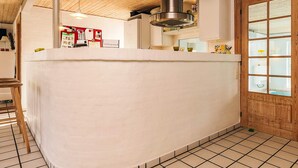 A kitchen with a wooden ceiling, a central island, and a view of the outside through a window. - 4 Star Holiday Home in Fur (Fur)