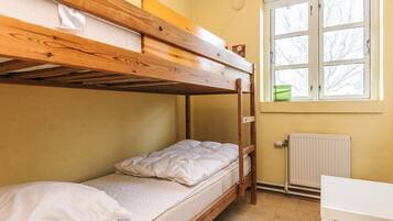 A bunk bed room with a window and radiator.
