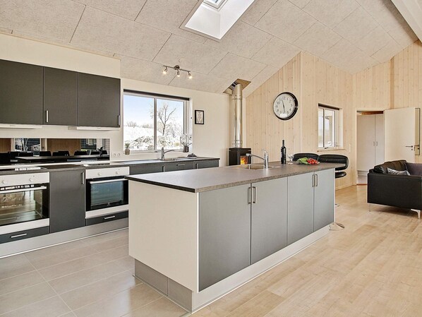 Una cucina moderna con isola centrale, elettrodomestici integrati e un'ampia finestra che offre luce naturale.