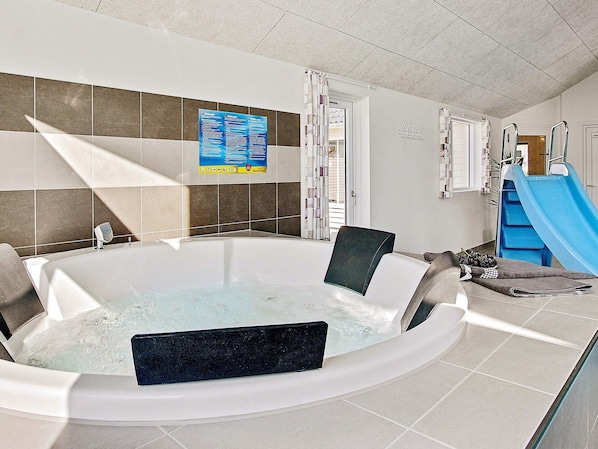 A modern bathroom with a hot tub, a blue slide, and a poster on the wall. - Holiday Home in Kappeln (Kappeln)