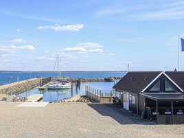 Un puerto deportivo con barcos amarrados, un muelle de madera y un edificio con techo oscuro.
