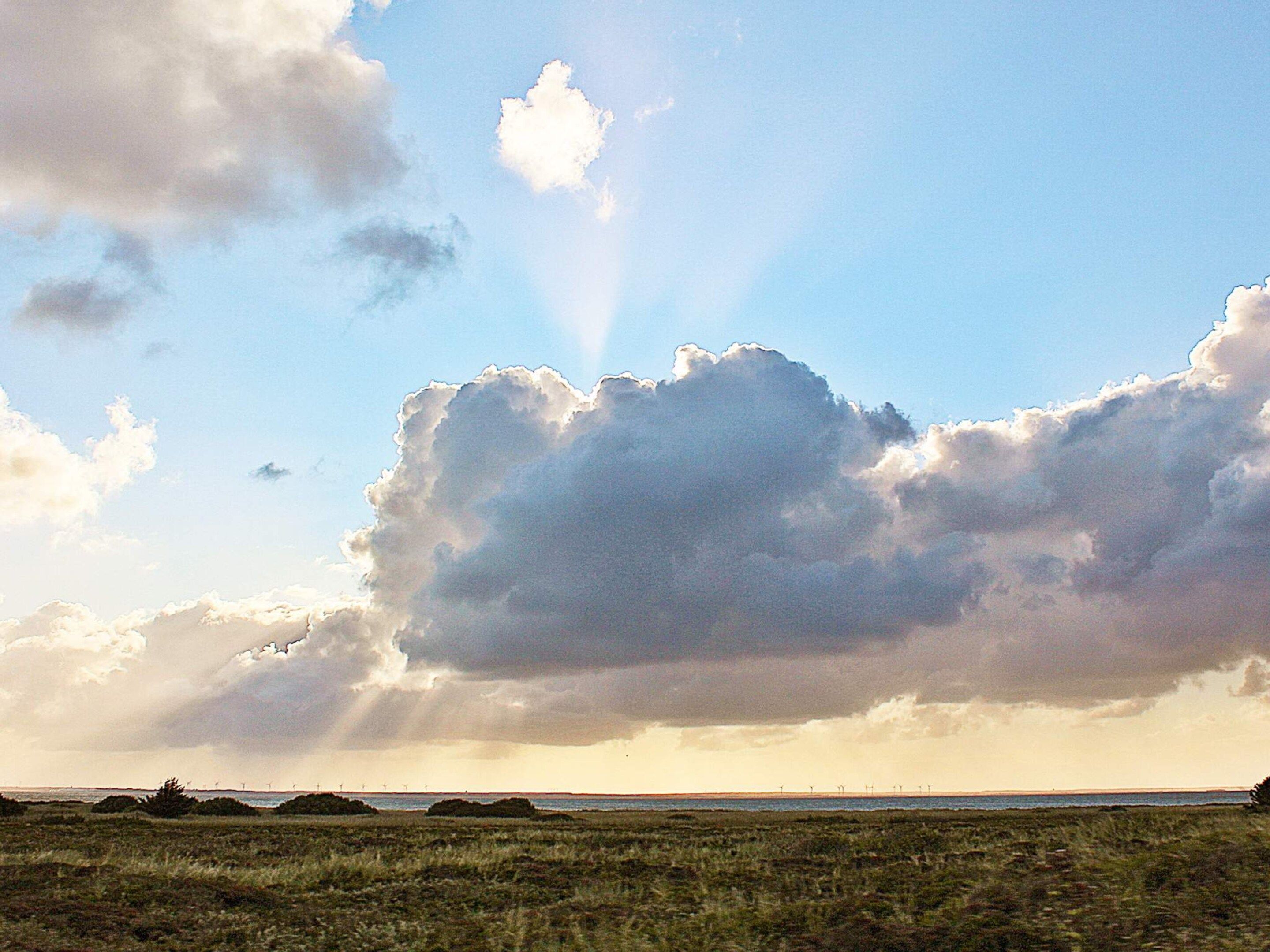 Paisaje con una gran formación de nubes y cielo despejado.
