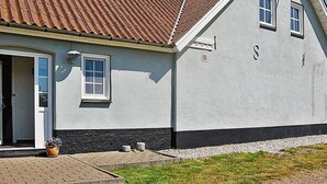 Um edifício com telhado inclinado, porta e janela.