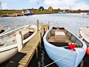 A dock with several boats, a wooden pier, and a small building in the background. - 6 Person Holiday Home in Hvide Sande-by Traum (Hvide Sande)