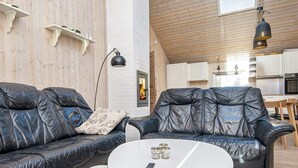 Un salon moderne avec des canapés en cuir, une table basse blanche et une cheminée.