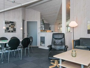 A modern interior with a dining area, a kitchen, and a seating area with a table and chairs.